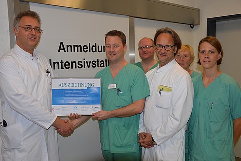 Die Internisten Michael Hohmann (Chefarzt Nephrologie, links im Bild) und Dr. Volker Meister (Chefarzt Gastroenterologie, rechts) übergeben die Auszeichnung an das Team der Intensivstation - hier stellvertretend für die Abteilung an Christian Heitmann (